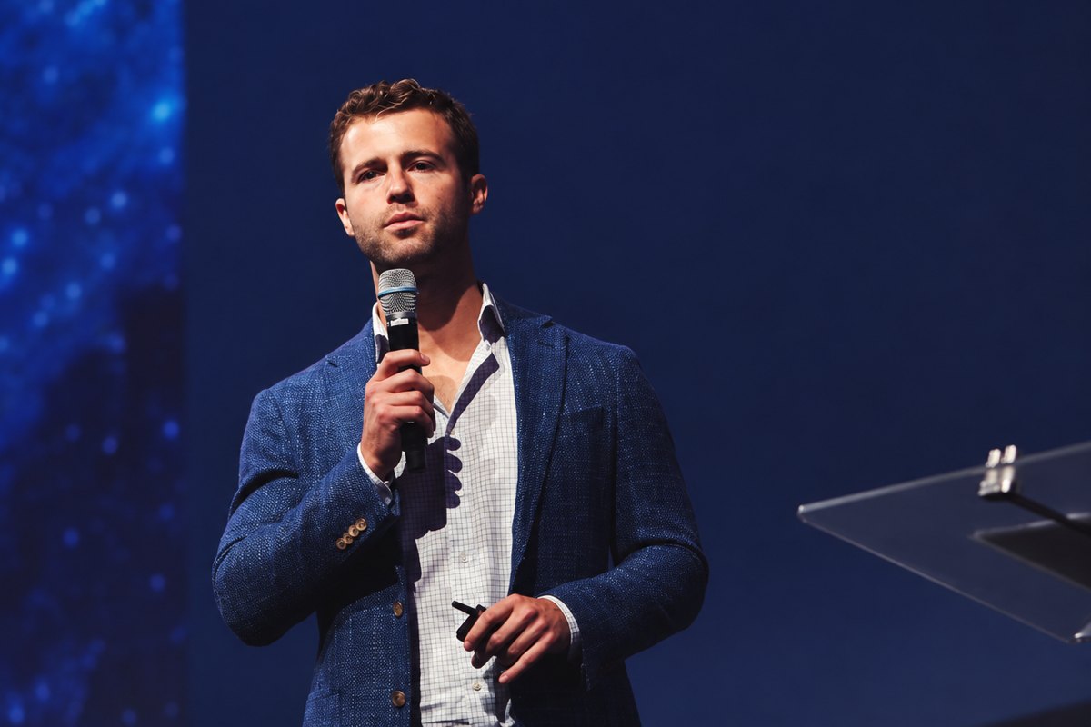Hunter speaking on stage, holding a microphone